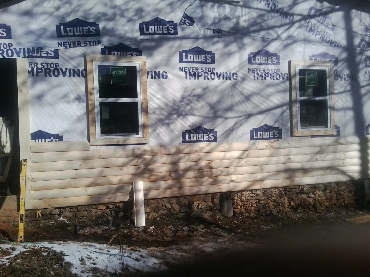 House wrap and new log siding going up on an exterior wall in Mc Connellsburg
