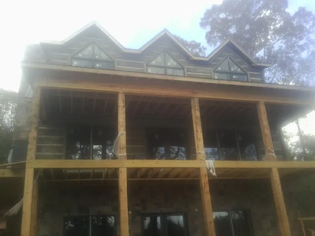 Dormers and porch framing on a large log home under construction — Roof Coating work by our crew in Mc Connellsburg