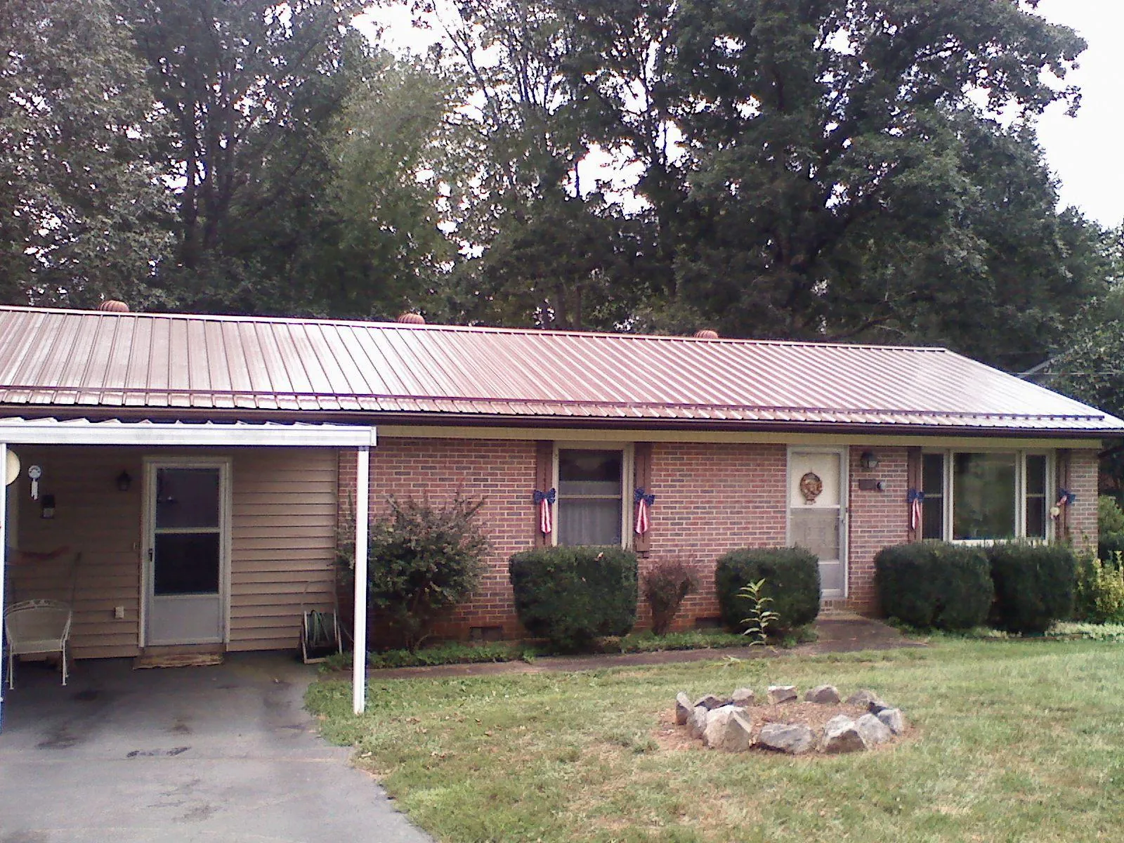 Bronze metal roof and carport on a brick ranch home — Roof Repair work by our crew in Mc Connellsburg